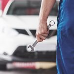 Hand of car mechanic with wrench. Auto repair garage