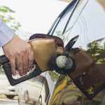 Man putting gasoline fuel into his car in a pump gas station